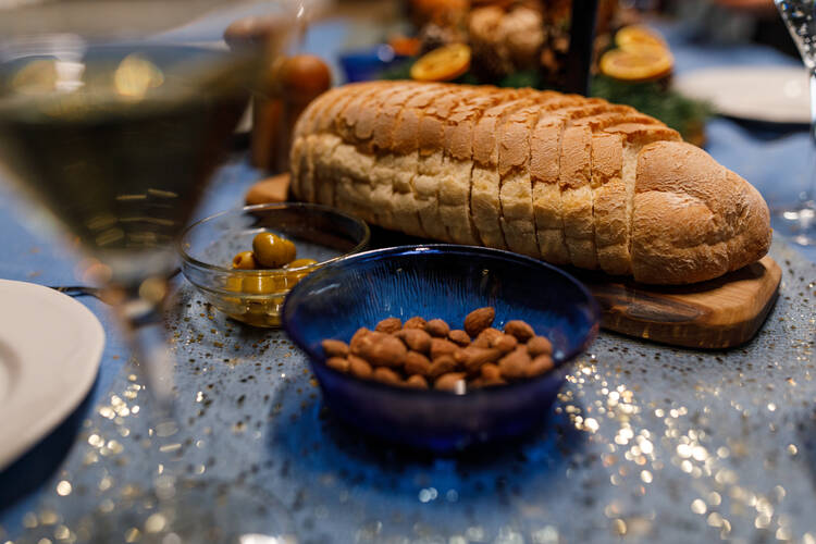 Close up shot of green olives, almonds and bread served on a dining table, to snack on as appetizer during a dinner party. (iStock/fotostorm)