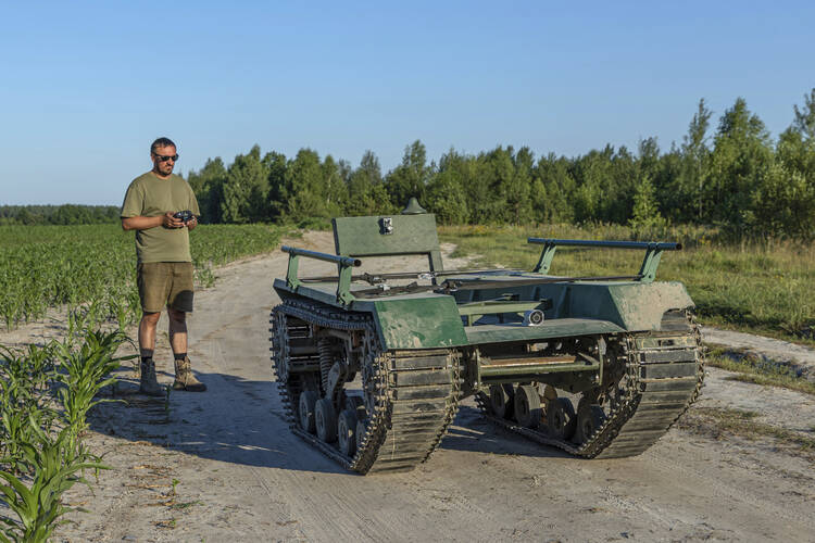 Andrii Denysenko, CEO of design and production bureau "UkrPrototyp," stands by Odyssey, a 1,750-pound ground drone prototype, at a corn field in northern Ukraine, on June 28, 2024. Facing manpower shortages and uneven international assistance, Ukraine is struggling to halt Russia’s incremental but pounding advance in the east and is counting heavily on innovation at home. (AP Photo/Anton Shtuka)