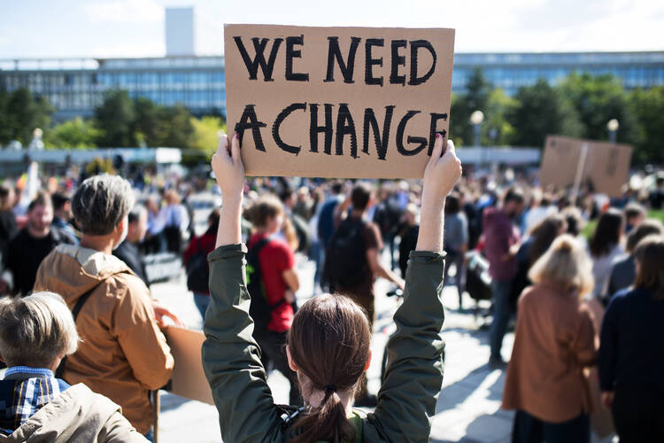 A rear view of people with placards and posters on global strike for climate change (iStock/Halfpoint)