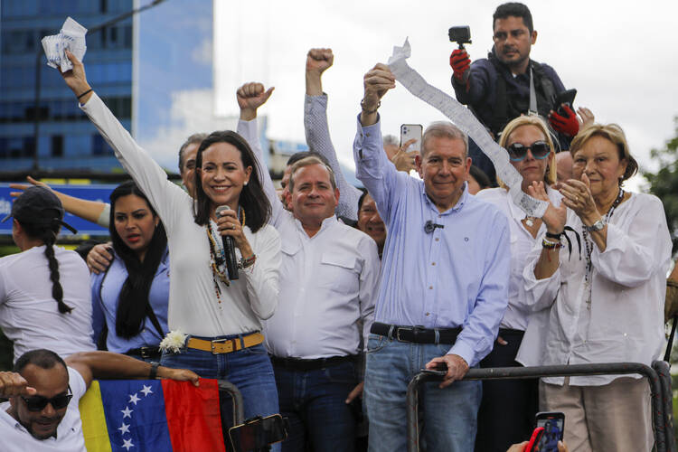 Opposition leader Maria Corina Machado, left, and opposition candidate Edmundo Gonzalez hold up vote tally sheets from the top of a truck during a protest against the official presidential election results declaring President Nicolas Maduro the winner in Caracas, Venezuela, on Tuesday, July 30, 2024, two days after the election. (AP Photo/Cristian Hernandez)