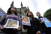 Members of the U.S.-based Survivors Network of those Abused by Priests, or SNAP hold portraits of themselves as youths as they address the media during a protest outside St. Mary's Catholic Cathedral in Edinburgh, Scotland