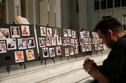 A man prays on June 15, 2016, in front of photographs of victims of the mass shooting at an L.G.B.T. nightclub in Orlando, Fla., during a vigil at a nearby church. The mass shooting was one of the hate crimes discussed on July 16 at a hearing held by the Helsinki Commission. (CNS photo/Jim Young, Reuters) 