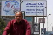 A man rides a bicycle past a billboard with an image of Pope Francis April 26 ahead of the pontiff's April 28-29 visit to Cairo. (CNS photo/Amr Abdallah Dalsh, Reuters)