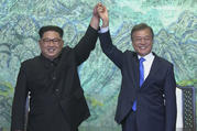 In this image made from video provided by Korea Broadcasting System (KBS), North Korean leader Kim Jong Un, left, and South Korean President Moon Jae-in raise their hands after signing on a joint statement at the border village of Panmunjom in the Demilitarized Zone Friday, April 27, 2018. (Korea Broadcasting System via AP)