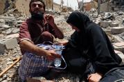 Displaced Iraqis rest amid rubble after fleeing fighting between Iraqi Counter Terrorism Service forces and Islamic State militants May 15 in Mosul. (CNS photo/Danish Siddiqui, Reuters)