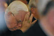 Boston Cardinal Bernard F. Law bows his head as a victim of clergy sexual abuse begins to address the U.S. bishops in 2002 in Dallas (CNS photo by Bob Roller).