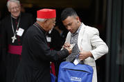  Ethiopian Cardinal Berhaneyesus Souraphiel of Addis Ababa checks out the name badge of Nathanael Lamataki, a youth delegate from the French territory of New Caledonia in the South Pacific, as they leave a session of the Synod of Bishops on young people, the faith and vocational discernment at the Vatican Oct. 5. (CNS photo/Paul Haring) 