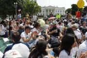 Demonstrators sit on the ground along Pennsylvania Ave. in front of the White House in Washington, on Saturday, April 29, 2017, during a demonstration and march. (AP Photo/Pablo Martinez Monsivais)