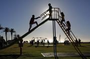 Children climb a slide in the public play area in Three Anchor Bay in Cape Town, South Africa, Dec. 29, 2014. 