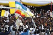 The Vatican flag and a peace banner are seen as Pope Francis greets the crowd as he arrives for a meeting with young people at the Kololo airstrip in Kampala, Uganda, Nov. 28 (CNS photo/Paul Haring). 