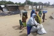 A woman leaves Kawuri, Nigeria, with her family and belongings after suspected Islamist Boko Haram insurgents killed 85 people in January.