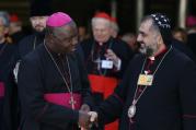 Archbishop Ignatius Ayau Kaigama of Jos, Nigeria, greets Syriac Orthodox Archbishop Yostinos of Zahle and Bekaa, Lebanon, as they leave the morning session of the extraordinary Synod of Bishops on the family at the Vatican Oct. 9. (CNS photo/Paul Haring)