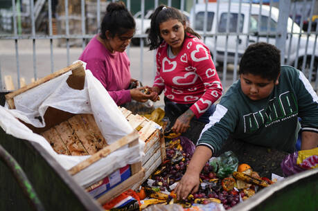 People pick through discarded produce at the central market for fruit and vegetables in Buenos Aires, Argentina, Friday, May 10, 2024. (AP Photo/Natacha Pisarenko)
